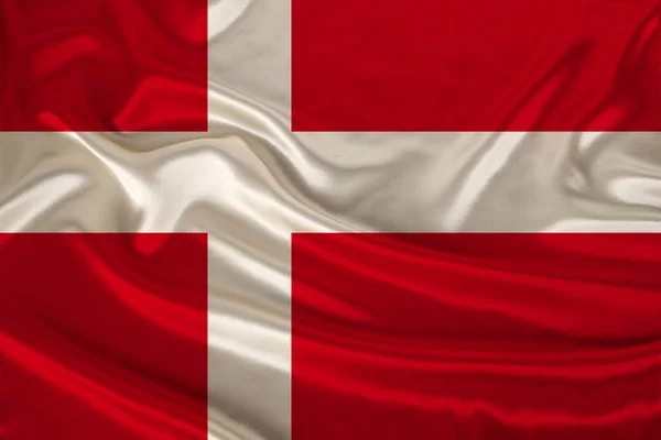 Photo of the national flag of Denmark on a luxurious texture of satin, silk with waves, folds and highlights, close-up, copy space, concept of travel, economy and state policy, illustration — Stock Photo, Image