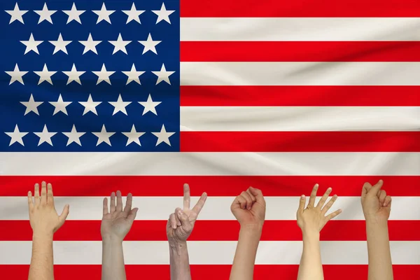 Muitas mãos levantadas de pessoas contra o pano de fundo de uma bandeira de estado de seda colorida com dobras macias, conceito de unidade de pessoas — Fotografia de Stock