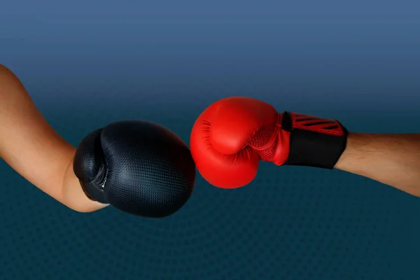 Manos de cerca de dos boxeadores en guantes de boxeo rojos y negros cerrados para el saludo deportivo sobre fondo oscuro con espacio para texto de copia —  Fotos de Stock