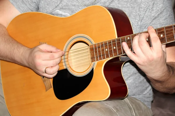 Férfi játszik egy hathúros fa gitár, zenei koncepció, közelkép — Stock Fotó