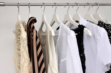 Beyaz ve renkli kadınlar askılarda giysi, moda ve alışveriş konsepti