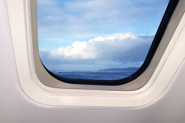 Hermoso cielo azul cielo paisaje con nubes esponjosas detrás del ojo de buey de un avión, concepto de viaje — Foto de Stock