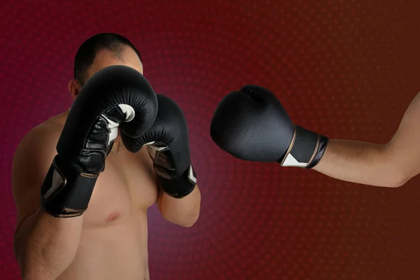 Fight of two boxers in black boxing gloves in protective stance, another boxer's hand hit, on a dark purple background, copy space, closeup — 스톡 사진