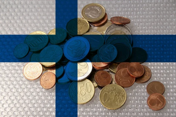 Metalen euromunten van de Europese munt tegen de achtergrond van de nationale vlag van het land Finland, het concept van financiële ontwikkeling, devaluatie, inflatie, belastingen — Stockfoto