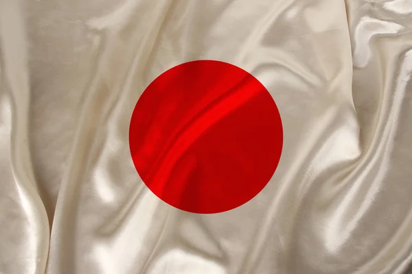 Foto bendera nasional Jepang pada tekstur mewah satin, sutra dengan gelombang, lipatan dan sorotan, closeup, ruang fotokopi, konsep perjalanan, ekonomi dan kebijakan negara, ilustrasi — Stok Foto