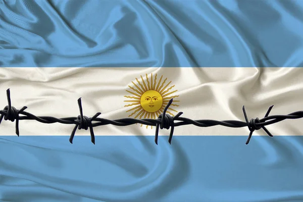 Arame farpado de ferro contra o pano de fundo da bandeira nacional da seda do estado argentino, prisão conceito para os infratores, para a área de cerco — Fotografia de Stock