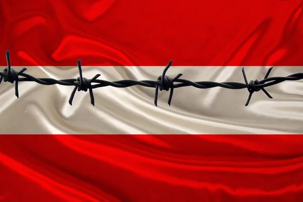 Żelazny drut kolczasty na tle narodowej jedwabnej flagi państwa austriackiego, koncepcja uwięzienia przestępców, oblężenia — Zdjęcie stockowe