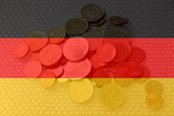 Monedas metálicas en euros de la moneda de la UE en el contexto de la bandera nacional del país de Alemania, el concepto de desarrollo financiero, devaluación, inflación, impuestos — Foto de Stock