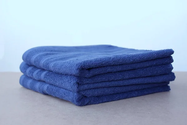 Купа чистих махрових бавовняних синіх рушників, крупним планом, на світлому тлі, копіювання простору, концепція чистоти, процедура ванни, спа — стокове фото