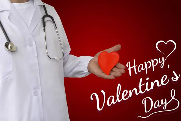 Lékař v bílé uniformě drží červené srdce v ruce, šťastný Valentýn, medik den, plakát pozadí, blahopřání šablony, pozvánka — Stock fotografie