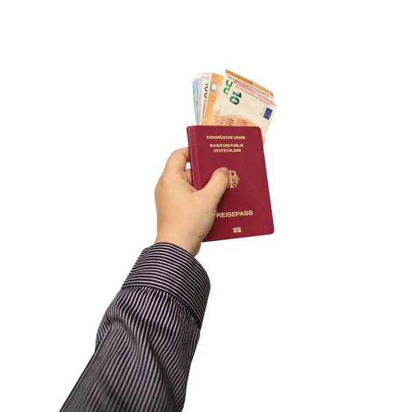 Мужская рука держит немецкий паспорт со вложенными банкнотами евро валюта евро на белом изолированном фоне — стоковое фото