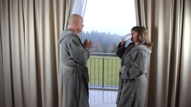 Positive Couple Man Woman Bathrobes Drink Coffee Window Hotel Room — Stock Video