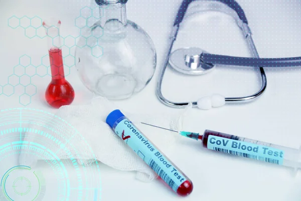 Medizinisches Laborteströhrchen mit dem Wort Coronavirus-Test auf Glas und Blut innen, Stethoskop, Fläschchen, Gefahrenkonzept der Ausbreitung des Cov-Virus — Stockfoto