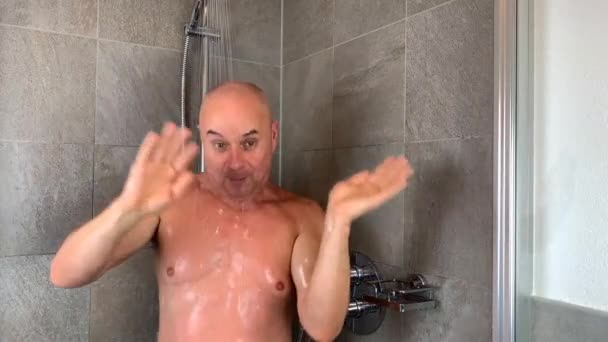 滑稽的秃头中年男子在淋浴间洗澡 并生动地描绘了他演奏乐器的情景 — 图库视频影像