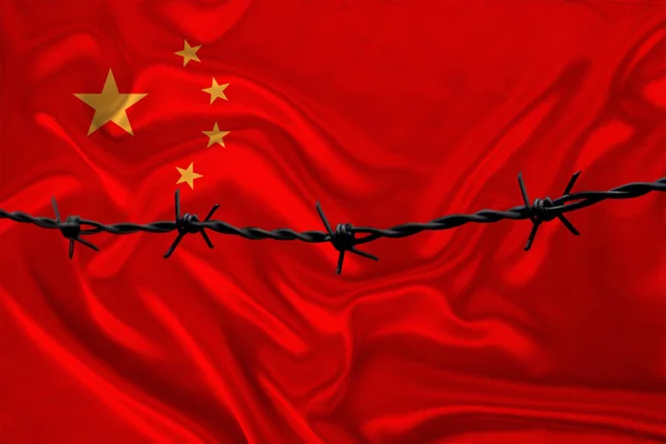Filo spinato di ferro sullo sfondo della bandiera nazionale di seta dello stato della Cina, concetto di reclusione per i trasgressori, per la zona d'assedio — Foto Stock