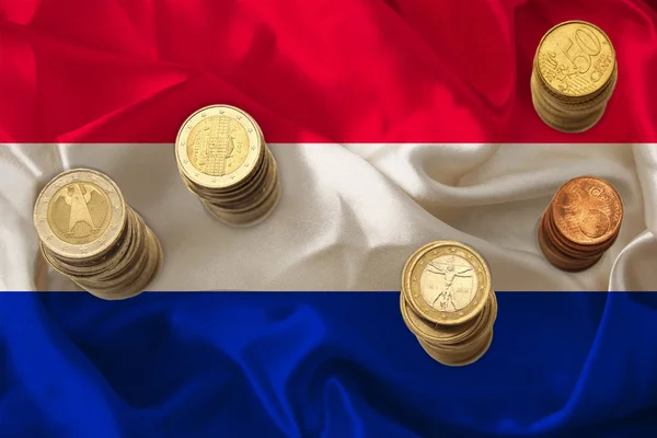 euro metal coins euro on the background of the national flag of the country of Netherlands, the concept of financial development, devaluation, inflation, taxes