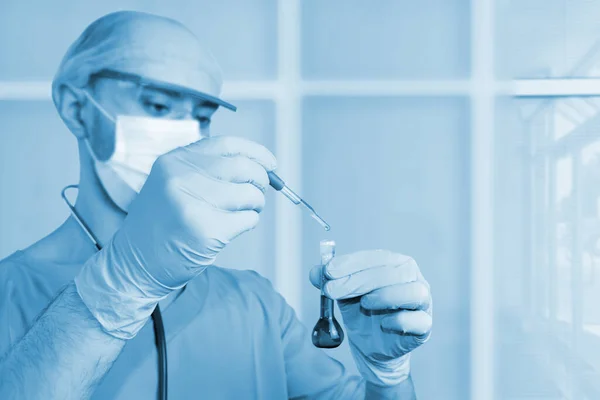 Мужчина-врач в синей форме со стетоскопом в защитной m — стоковое фото