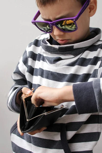 Junge mit dunkler Sonnenbrille, in gestreiftem Pullover, nimmt Papierscheine der EU-Banknoten, Kopierraum, lila Hintergrund, Nahaufnahme, senkrecht — Stockfoto