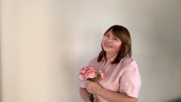 Γυναίκα Μυρίζει Ένα Μπουκέτο Ροζ Λουλούδια Γαρύφαλλα Χαμόγελα Έννοια Των — Αρχείο Βίντεο