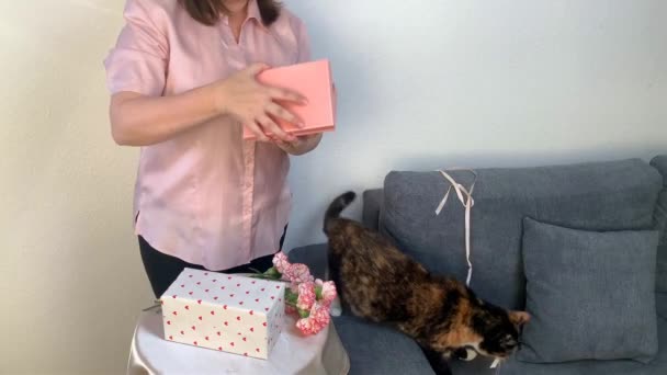 Γυναίκα Ανοίγει Δώρα Κουτιά Ένα Μπουκέτο Ροζ Λουλούδια Γαρύφαλλα Στέκεται — Αρχείο Βίντεο