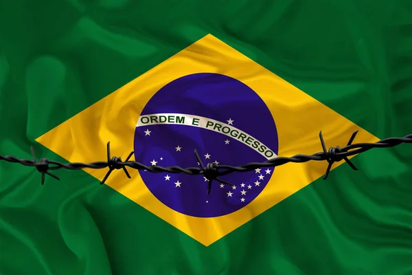 Залізний колючий дріт на тлі національного шовкового прапора штату Бразилія, концепція ув'язнення для правопорушників, для облоги території. — стокове фото