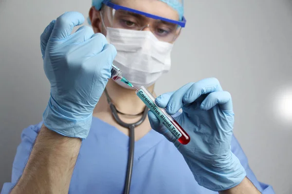 Orvosi laboratóriumi kémcső és fecskendő vérrel a kezében egy virológus orvos, koncepció a virológia, járvány, terjedése coronavirus — Stock Fotó