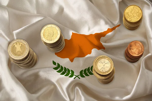 Metal currency coins on the background of the national flag of the country of Cyprus, the concept of financial development, devaluation, inflation, taxes — Stock Photo, Image
