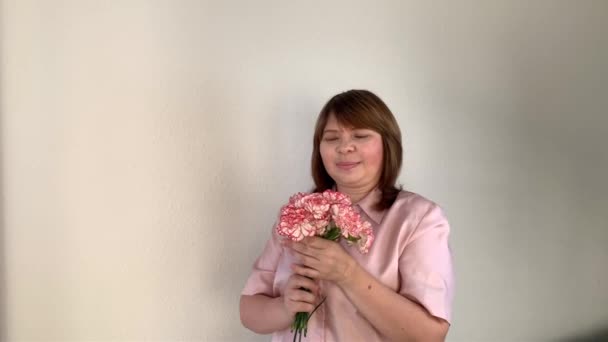 Vrouw Houdt Een Boeket Van Roze Bloemen Van Anjers Glimlacht — Stockvideo