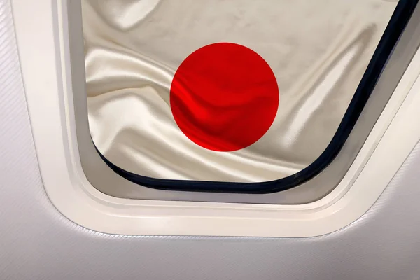 Bandera nacional del estado moderno de Japón en el ojo de buey de un avión, concepto de viaje, turismo, emigración — Foto de Stock