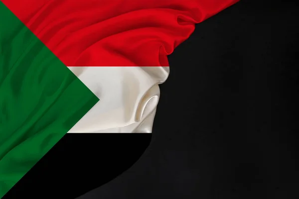 Silk national flag of Sudan state folded onto black blank form, concept of tourism, economy, politics, emigration — Stock Photo, Image