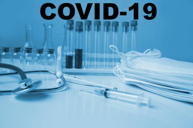 İçinde kan olan tıbbi laboratuvar tüpü, stetoskop, şırınga, koruyucu maskeler, Coronavirus Covid-19 virüsünün yayılma tehlikesi kavramı.