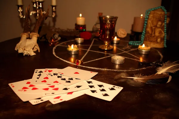 Velas são acesas em um quarto escuro em uma mesa redonda, em candelabros de prata, cartões de adivinhação são dispostos, um pentagrama é desenhado, um conceito de magia e bruxaria — Fotografia de Stock