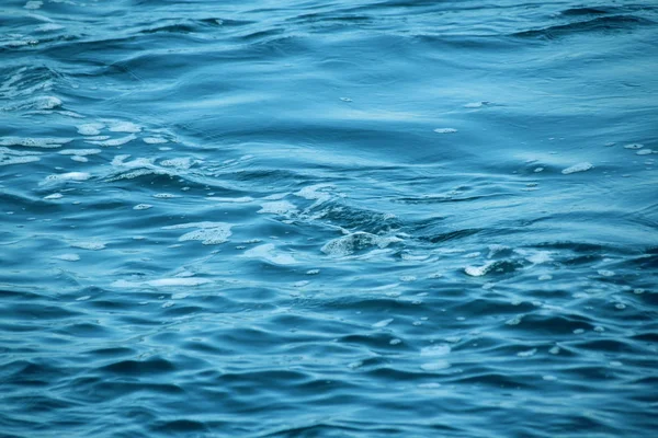 Błękitne morze, fale oceanu, woda z pianki i pęcherzyków, tekstura, koncepcja zasobów naturalnych wody, zbliżenie, przestrzeń kopiowania — Zdjęcie stockowe