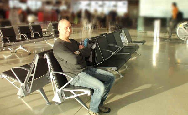 Passageiro do sexo masculino esperando seu voo sentado na cadeira lounge do aeroporto, concerto de viagem — Fotografia de Stock