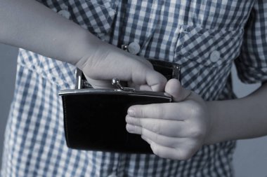 kid holds a wallet and takes out with his hand, the concept of p