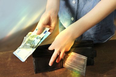 Çocuğun elinde euro banknotları ve siyah cüzdan, cep harçlığı konsepti, hırsızlık, alışveriş