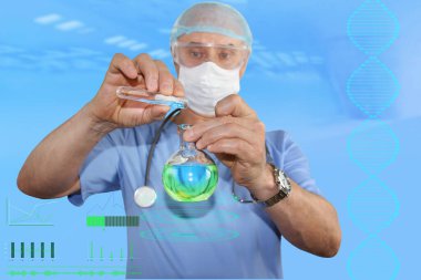 Mavi üniformalı, koruyucu maskeli ve gözlüklü bir erkek doktor laboratuvar testi yapıyor, tıbbi bir şişeye sıvı döküyor.