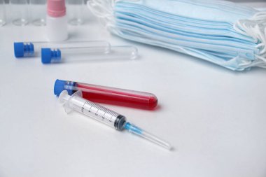 Tıbbi laboratuvar test tüpleri, stetoskop, şırınga, tek kullanımlık koruyucu maskeler, virüse karşı kişisel koruma kavramı, COVID-19 koronavirüs, grip, enfeksiyon