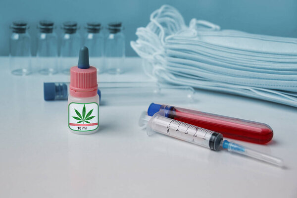 лабораторные трубки, одноразовые медицинские маски, бутылка медицинского конопли, концепция здоровья, страхования и лечения
