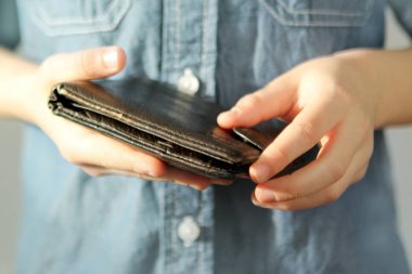 Çocuk elinde bir cüzdan tutuyor, parmaklarıyla açmaya çalışıyor, cep harçlığı konsepti, hırsızlık, alışveriş