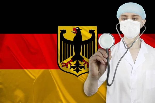 以德国丝绸国旗为背景的听诊器医生 国家医疗 保险和旅游的概念 — 图库照片