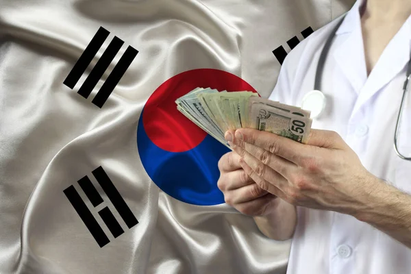 Male Doctor Holding Fan Dollar Banknotes His Hands Backdrop South — Stock Photo, Image