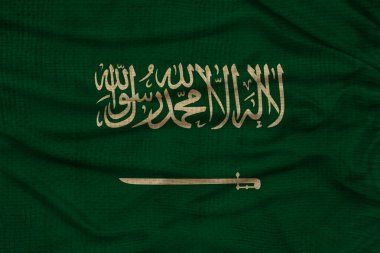 Modern Suudi Arabistan 'ın güzel renkli ulusal bayrağının dokulu kumaş, turizm, ekonomi ve siyaset konsepti üzerindeki fotoğrafı, yakın plan