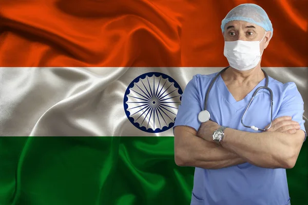 male doctor with a stethoscope on the background of the india silk national flag, concept of national medical care, health, insurance, tourism