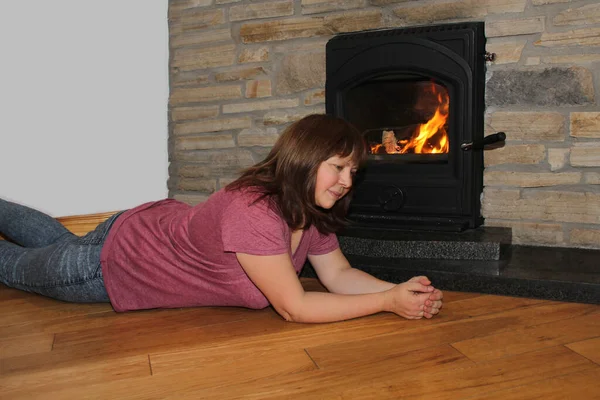 woman lies near a burning fireplace and thinks, concept of winter mood
