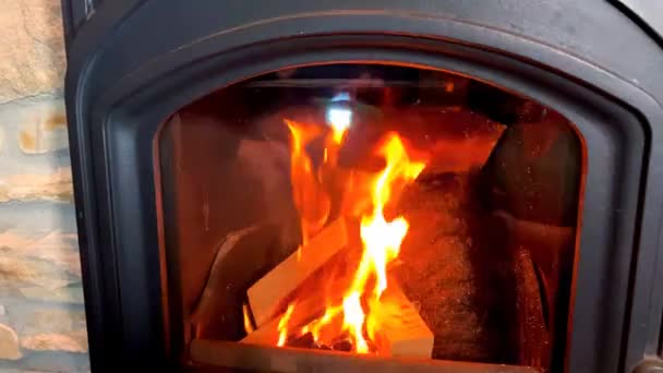 flamme orange vif brûle dans une cheminée noire, concept de maison confortable