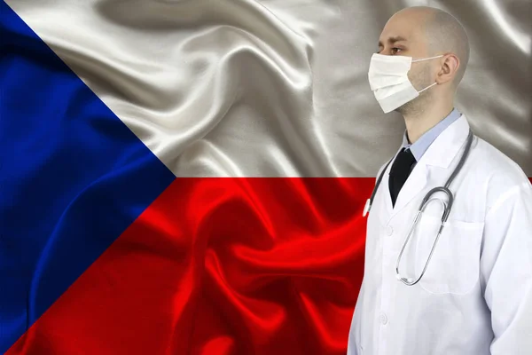 male doctor with a stethoscope against the background of the silk national flag of Czech Republic, concept of national medical care, health, insurance, tourism