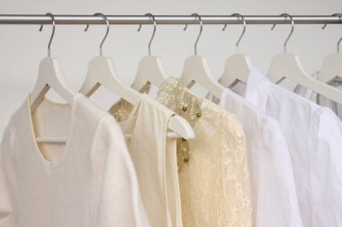Askıda beyaz kadın kıyafetleri, moda ve alışveriş konsepti. 