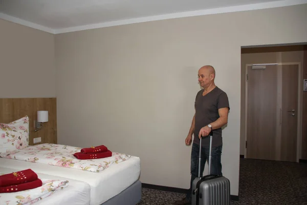 Дорослий Чоловік Валізою Стоїть Готельному Номері Дивиться Ліжко Концепція Відпустки — стокове фото