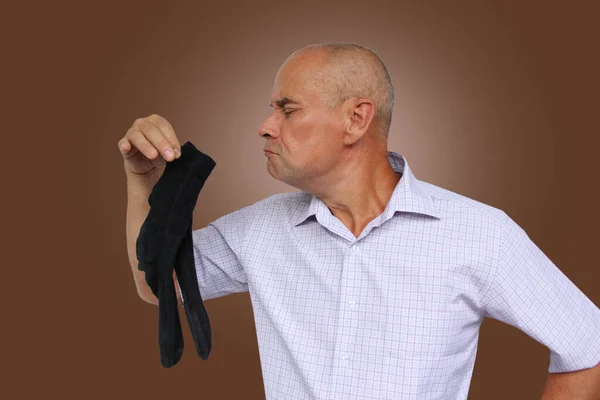 Hombre Con Una Camisa Ligera Sostiene Calcetines Negros Mano Los —  Fotos de Stock